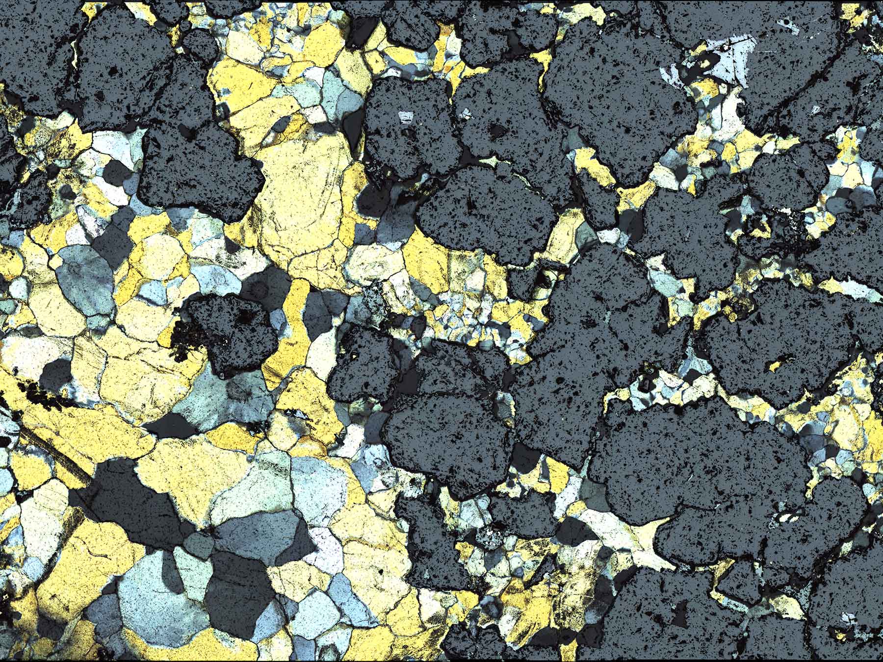Transmitted light image of a thick section containing opaque minerals, mostly sphalerite, with some galena, and trace chalcopyrite.